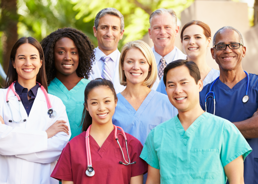 A photo of diverse healthcare professionals wearing suits, white lab coats, nursing scrubs and stethescopes.